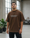 Modelo vestindo a Camiseta Oversized Grizzly Outdoor Division marrom, vista frontal