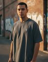 Modelo vestindo a Camiseta Oversized Grizzly Griptape Bumper cinza-escuro, vista frontal