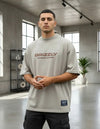 Modelo vestindo a Camiseta Oversized Grizzly Outdoor Division bege, vista frontal