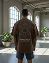 Modelo vestindo a Camiseta Oversized Grizzly Outdoor Division marrom, vista das costas