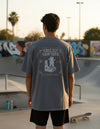 Modelo vestindo a Camiseta Oversized Grizzly Griptape Bumper cinza-escuro, vista das costas